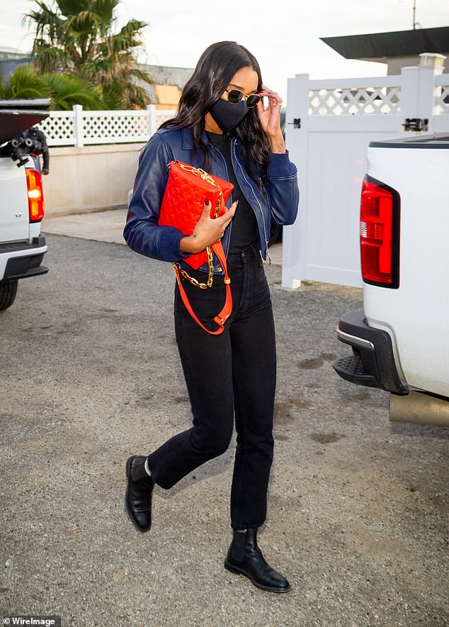 Laura Harrier in laid back look: blue leather jacket and black jeans